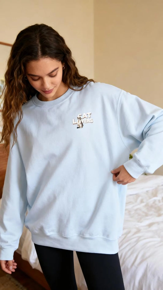 Minimal Cat Lover Unisex Crewneck Sweatshirt displayed on a model in a soft blue color, featuring an embroidered motif.
