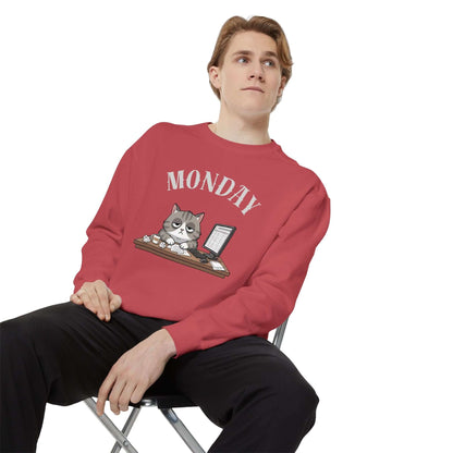 Monday Face Cat Stares Blankly Unisex Crewneck Sweatshirt worn by a model sitting on a chair.
