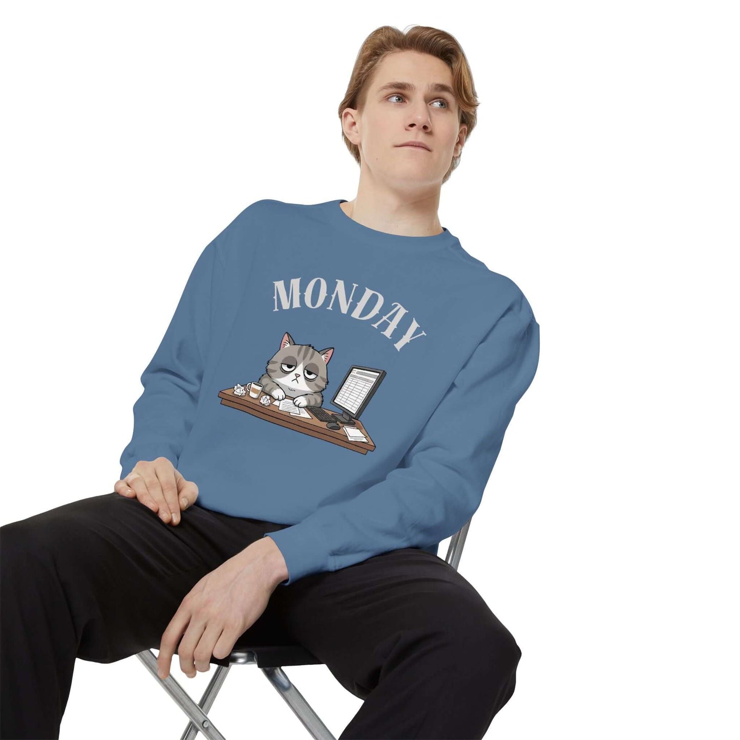 Monday Face Cat Stares Blankly Unisex Crewneck Sweatshirt worn by a model sitting on a chair.