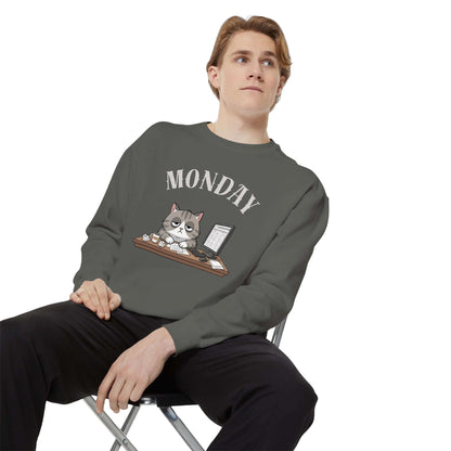 Monday Face Cat Stares Blankly Unisex Crewneck Sweatshirt worn by a man sitting on a chair with a gray background.